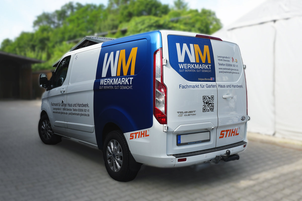 Ein weißes Lieferauto, das hinten Blau ist, mit der Aufschrift Werkmarkt, Fachmarkt für Garten Haus und Handwerk